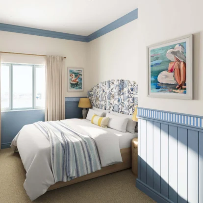 Cosy hotel room with blue accents and seaside-themed artwork.