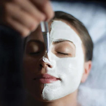 Relaxed woman enjoying a rejuvenating facial treatment at a luxury spa.