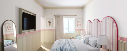 Cosy hotel room with striped bedding and large TV, softly lit by a window.
