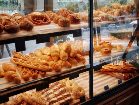 A bakery display with assorted fresh pastries and breads in a cosy hotel cafe.