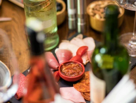A family enjoys a charcuterie board with wine, showcasing a relaxed dining scene at a resort.