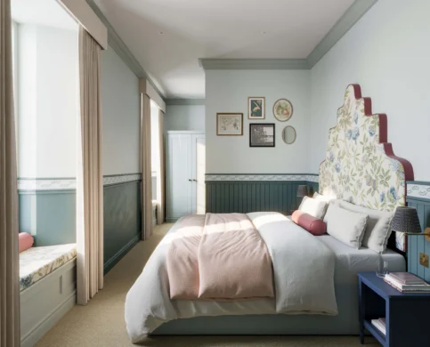 Cosy hotel room with a large bed, soft light, and elegant decor inviting relaxation.