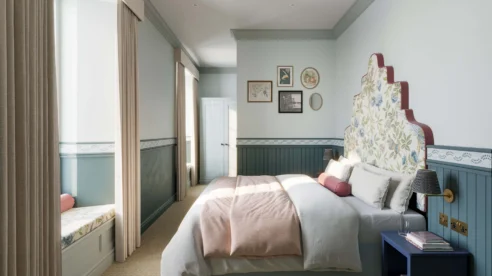 Cosy hotel room with a large bed, soft light, and elegant decor inviting relaxation.