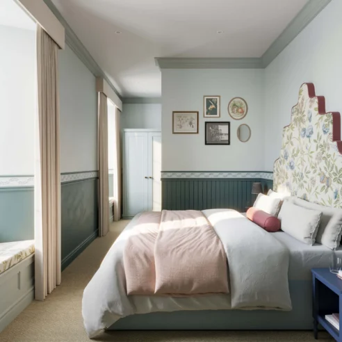 Cosy hotel room with a large bed, soft light, and elegant decor inviting relaxation.